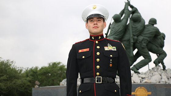un cadete en el monumento de iwo jima vestido con blues