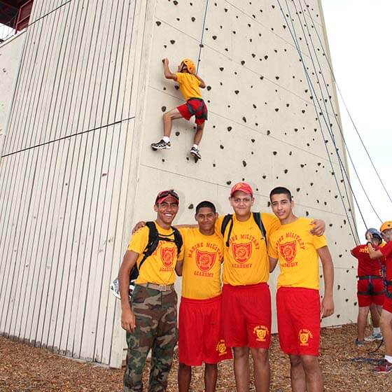 cadete de campamento de verano escala la pared de escalada