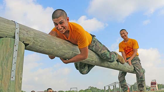 cadetes de campamento de verano superando un obstáculo